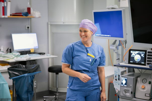 En vårdpersonal i arbetskläder i undersökningsrum. Foto.